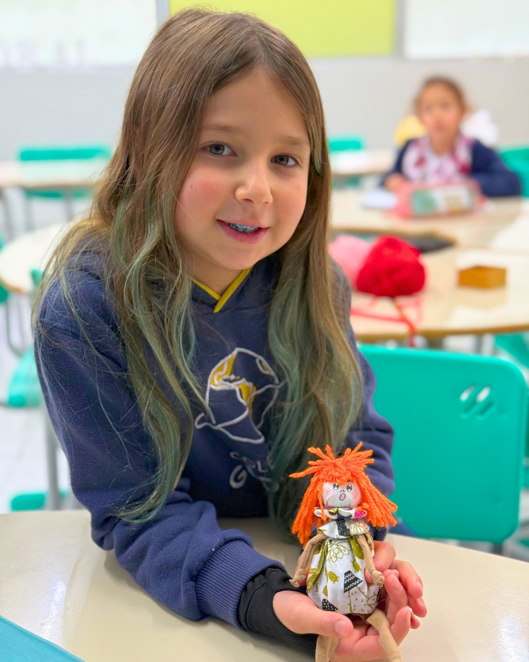 Aluna do Período Integral do Colégio Global com a boneca que fez na atividade de customização